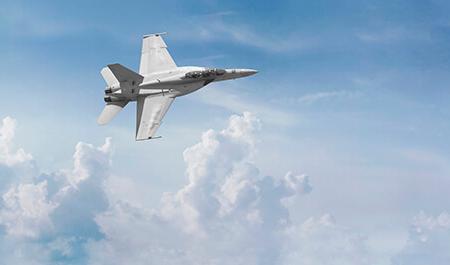 Panoramic view of an F-18 fighter jet cutting across the sky.