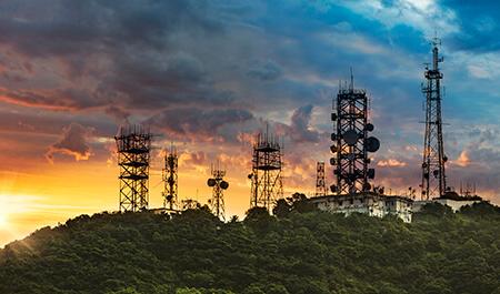 轮廓天线塔和中继器的通信和电信与山的背景上的日落.